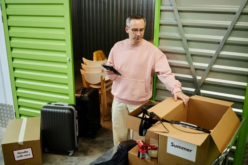 A man organizing his items for stage right outside of his unit.